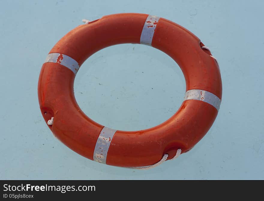 Safe water support aid circle with rope. Rescue red life buoy on wooden background of ship or boat. Helpful object. Safe water support aid circle with rope. Rescue red life buoy on wooden background of ship or boat. Helpful object.