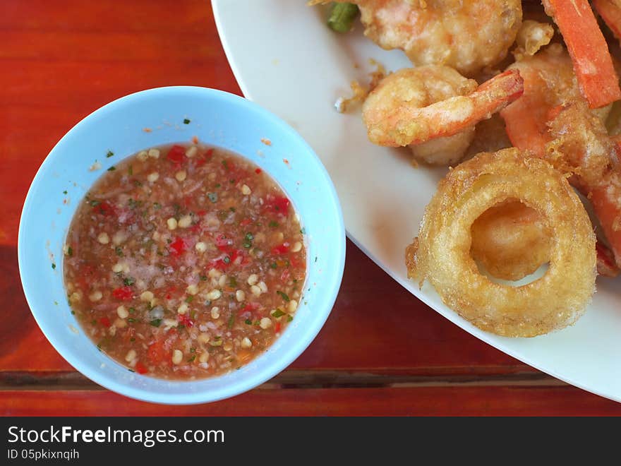 Fried vegetables and fried shrimp with sauce on table