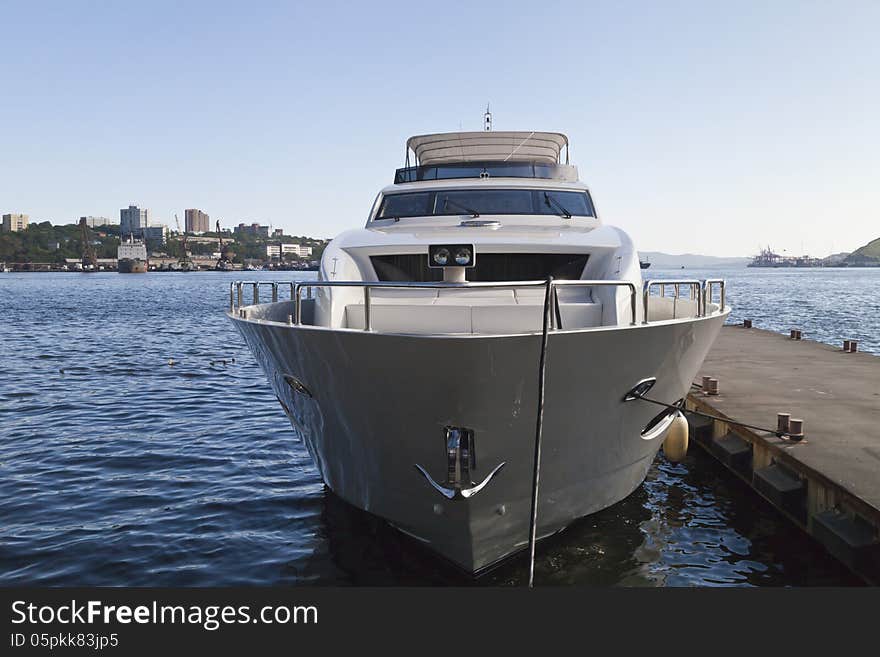 The boat at the mooring costs waiting for passengers in the light of a bright sun