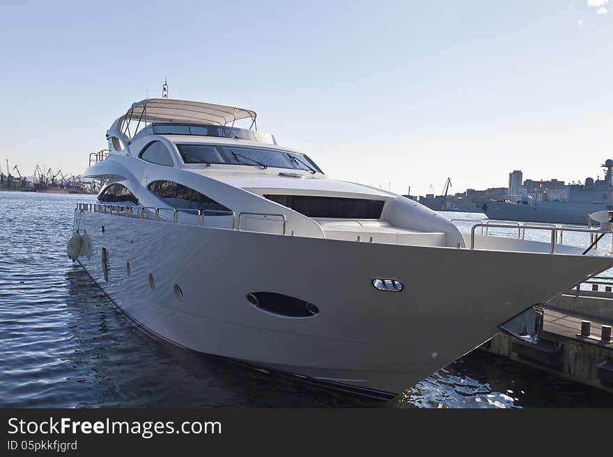 The boat at the mooring costs waiting for passengers in the light of a bright sun