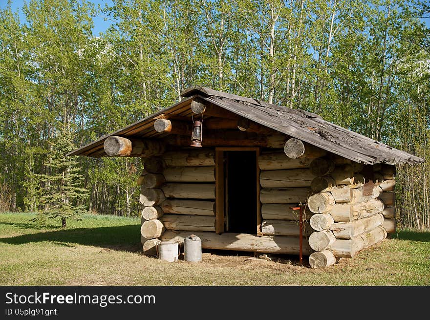 Outside of Trappers Log Cabin with lantern and other tools.