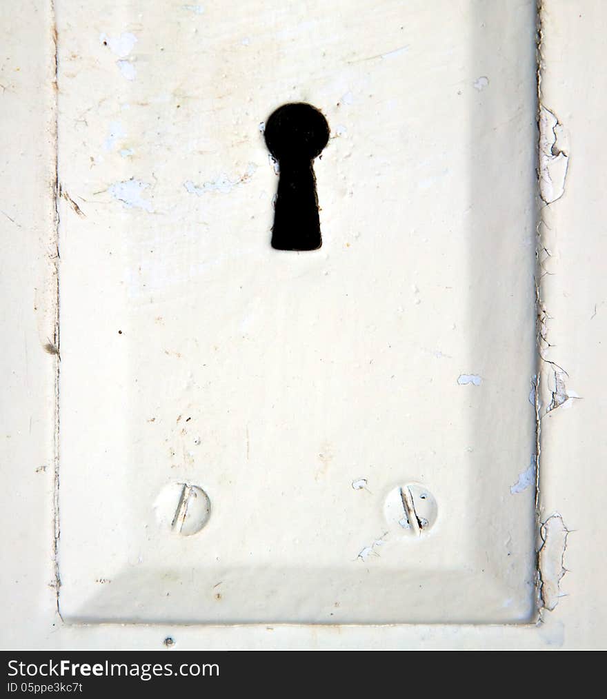 An antique key hole on an old weathered door. An antique key hole on an old weathered door