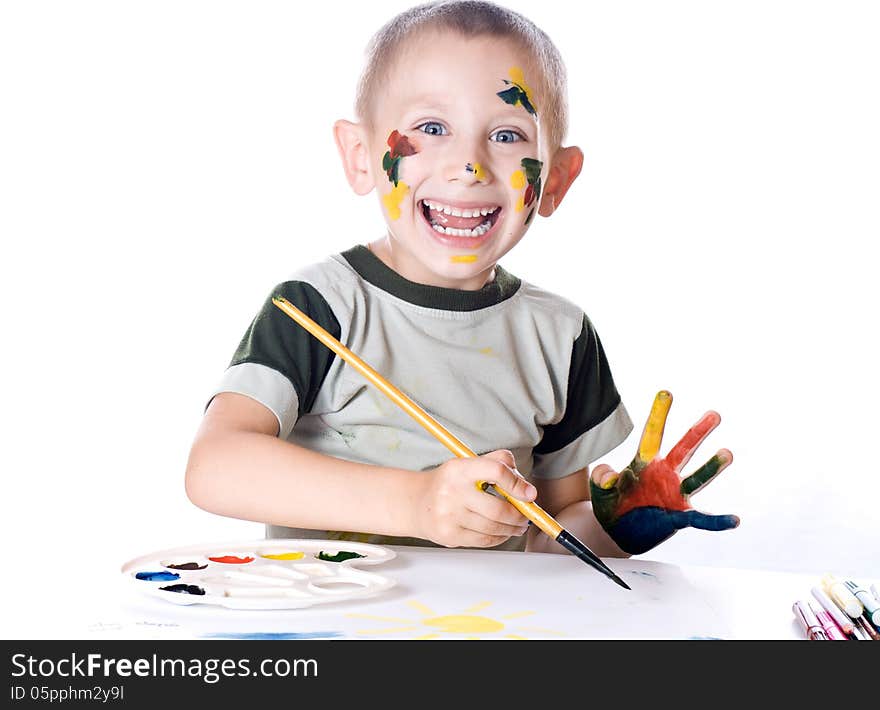 Boy paints watercolors paints on a sheet of paper. Boy paints watercolors paints on a sheet of paper