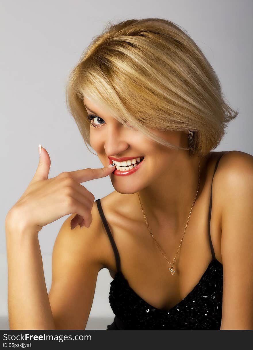 Portrait of a beautiful young woman in a black dress in studio