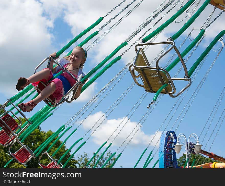 Girl riding a chained carousel