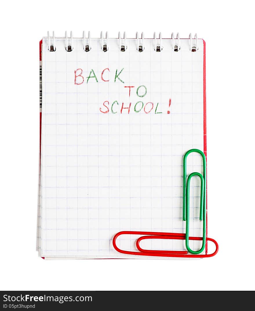 Notebook with phrase Back to school with red and green clips isolated