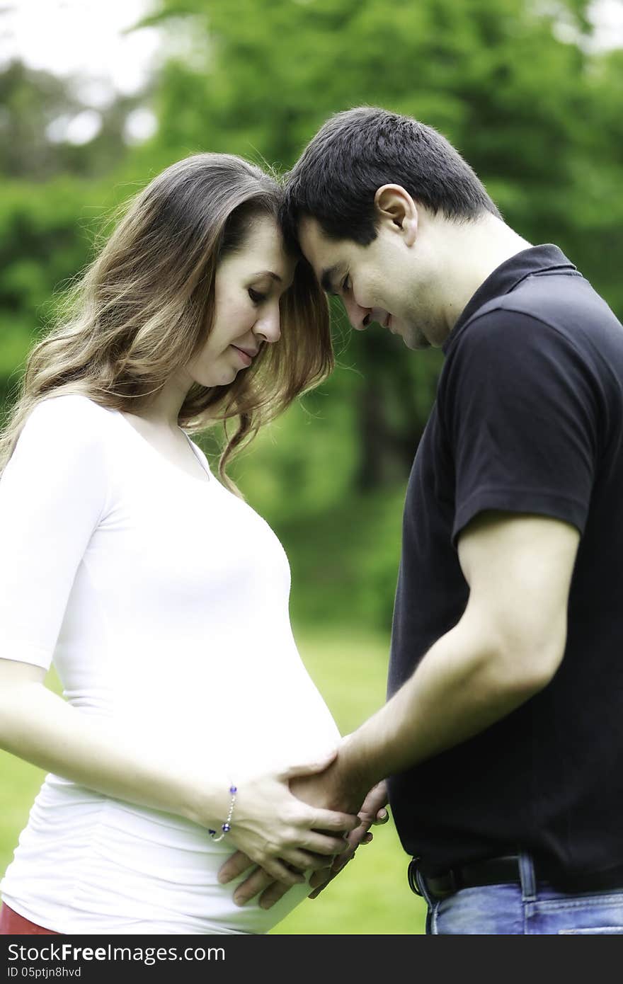 Pregnant couple in love holding pregnant belly. Pregnant couple in love holding pregnant belly