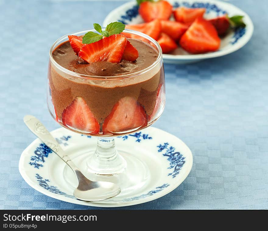 Photo of delicious chocolate mousse with strawberries on blue napkins. Photo of delicious chocolate mousse with strawberries on blue napkins