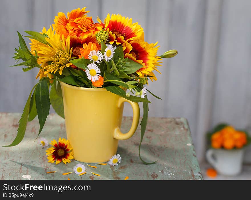 Bouquet of summer flowers in a vase before wooden background. Bouquet of summer flowers in a vase before wooden background