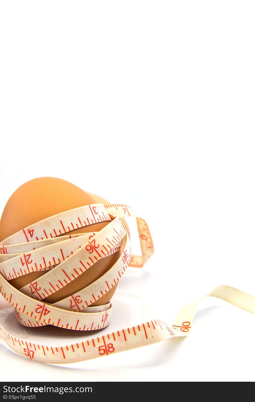 Measurement Tape Wrapped Around The Egg on white background. Measurement Tape Wrapped Around The Egg on white background.