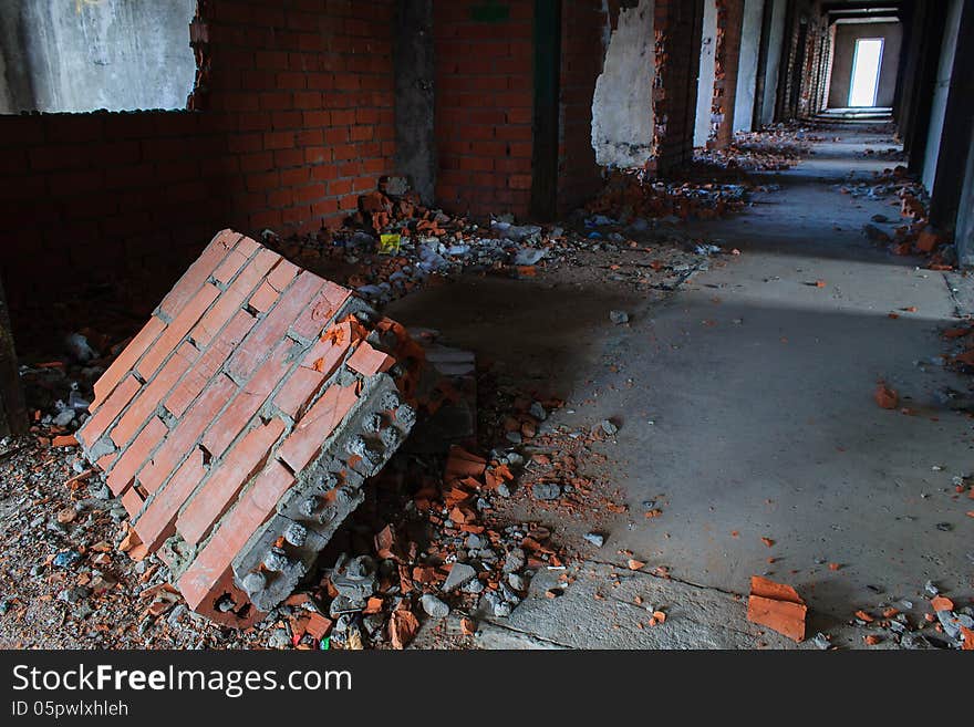 Corridor with a piece of the fallen brick wall in the foreground. Corridor with a piece of the fallen brick wall in the foreground