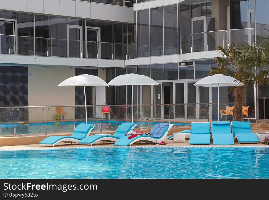 Lounge chairs with umbrella near the swimming pool