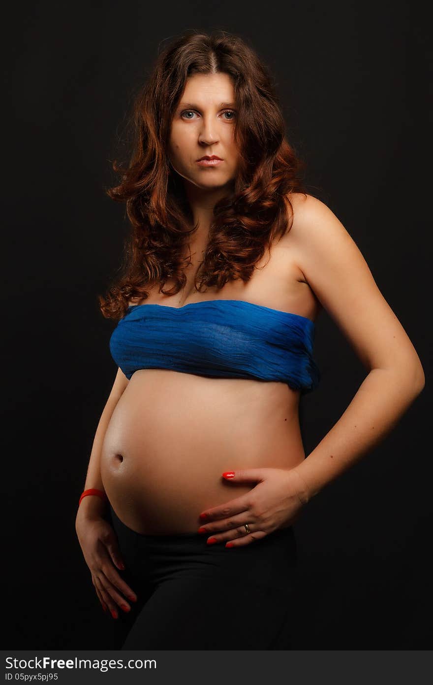 Pregnant woman portrait over dark background