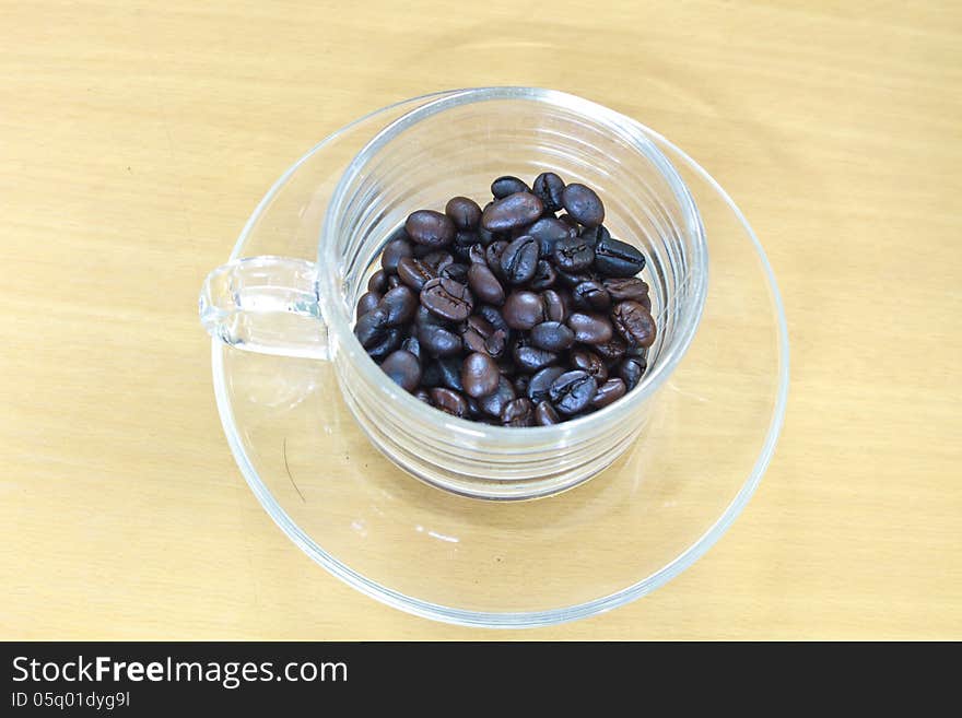 Coffee beans in cup on the wood table