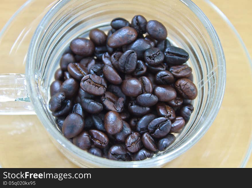 Coffee beans in cup on the wood table