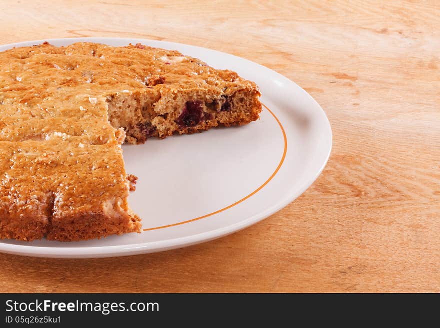 Homemade cake with cut piece on a wooden table