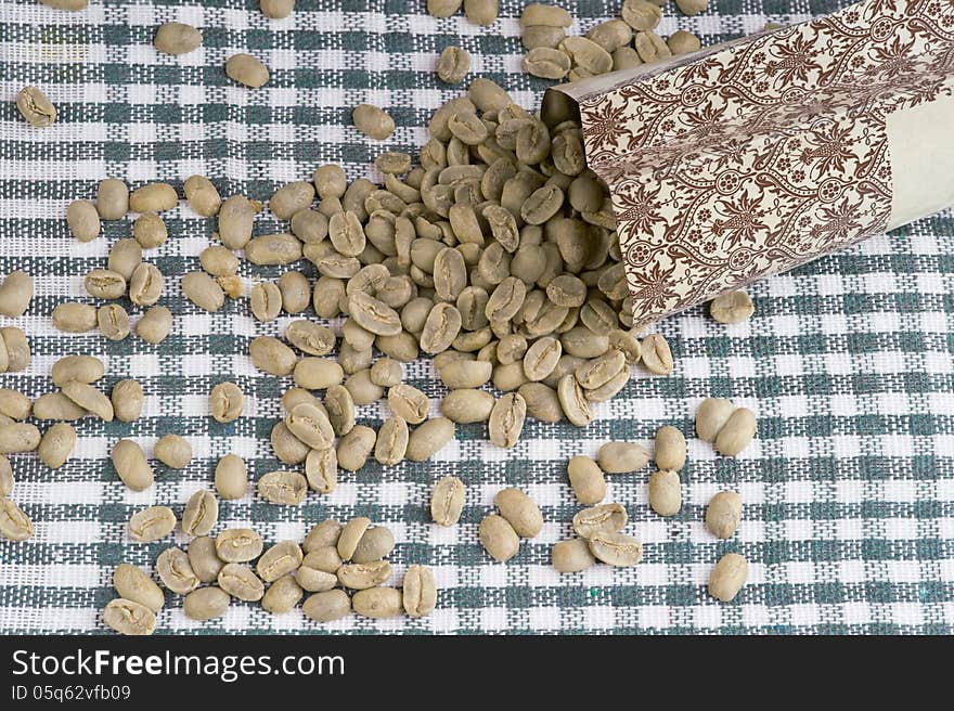 Heap of not roasted coffee beans on tablecloth. Maragogype. Heap of not roasted coffee beans on tablecloth. Maragogype.