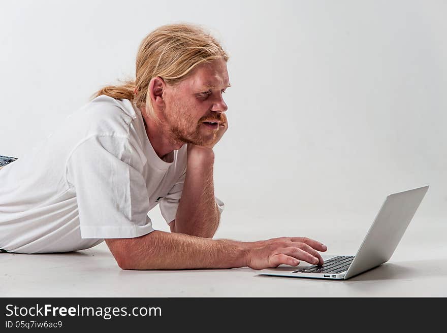 Serious man with laptop on the white background