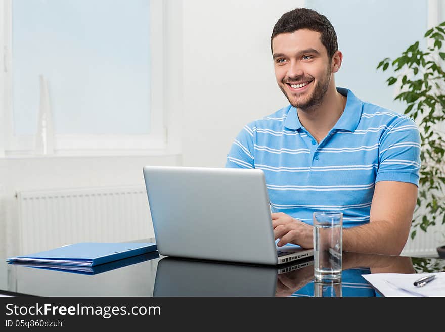 Happy Businesswoman Sitting At Table With Laptop