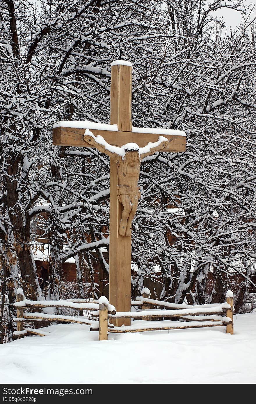 Wooden carved crucifix under the snow