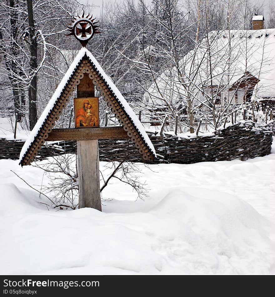 Icon on wooden cross under the snow