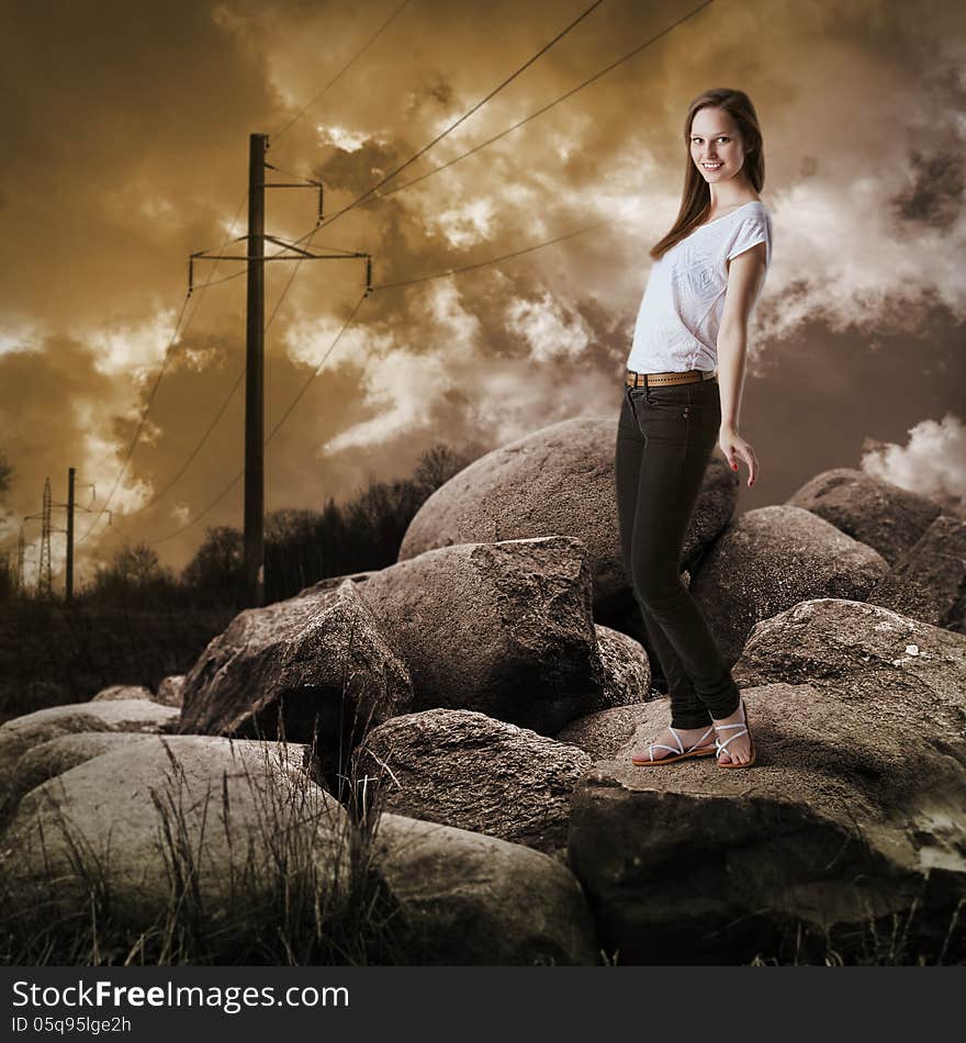 Young girl in jeans standing on large rocks. Young girl in jeans standing on large rocks