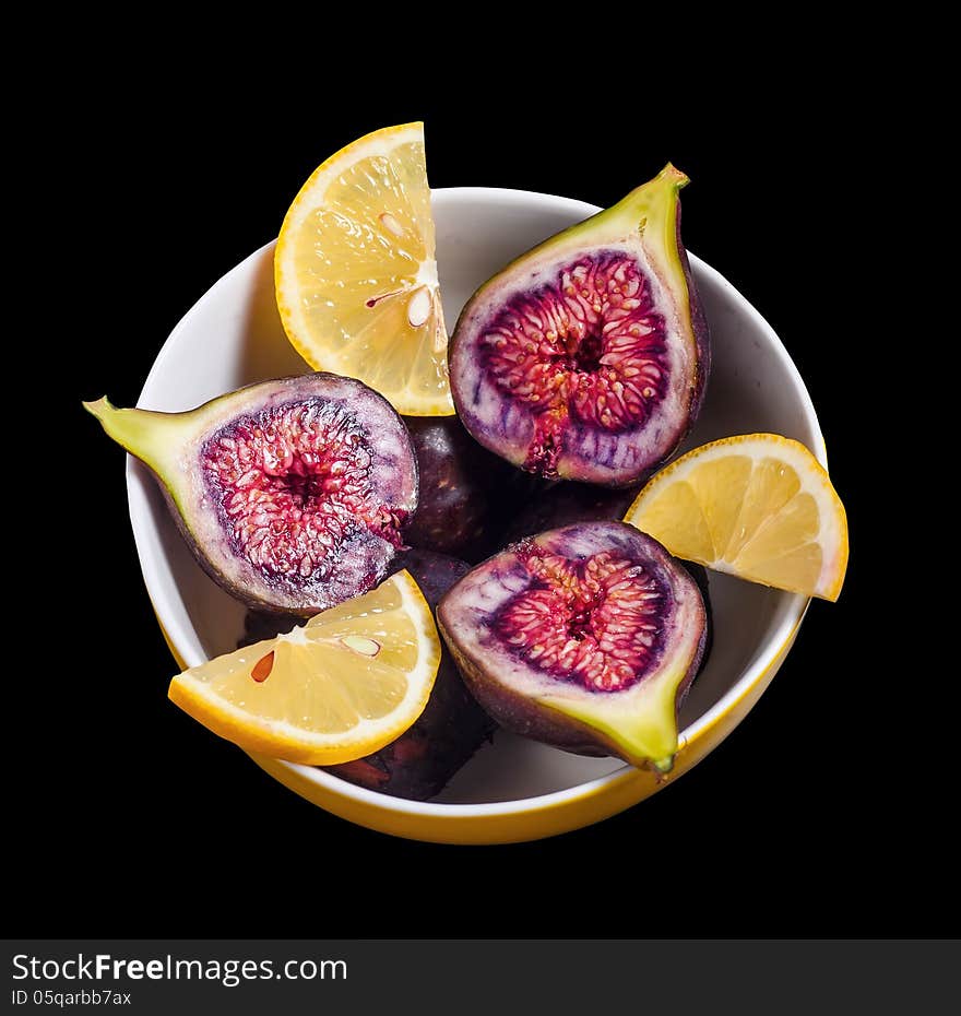 Fruits figs and lemons on black background