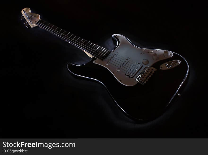 A Black guitar outlined over a dark background. A Black guitar outlined over a dark background