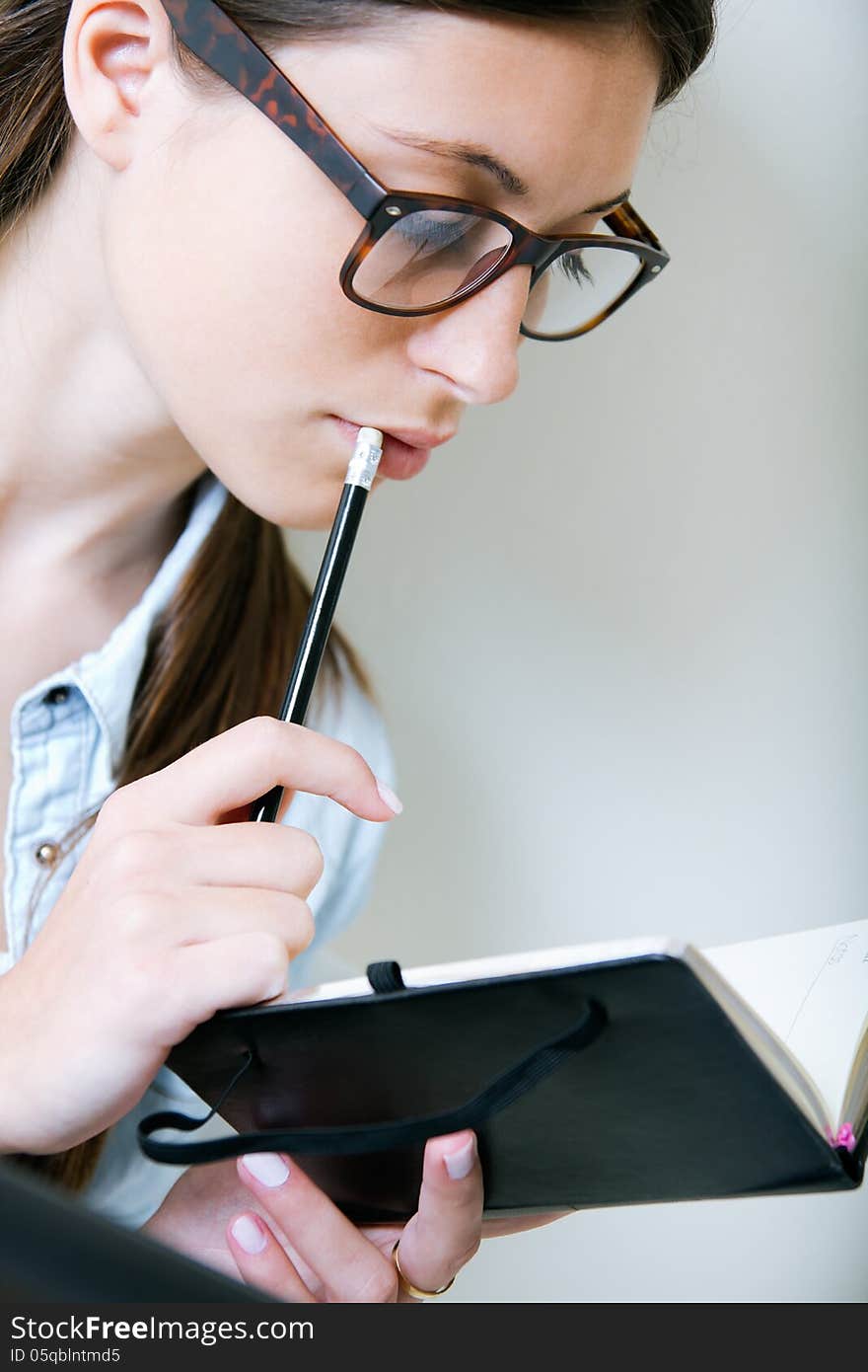 Young woman taking notes at home