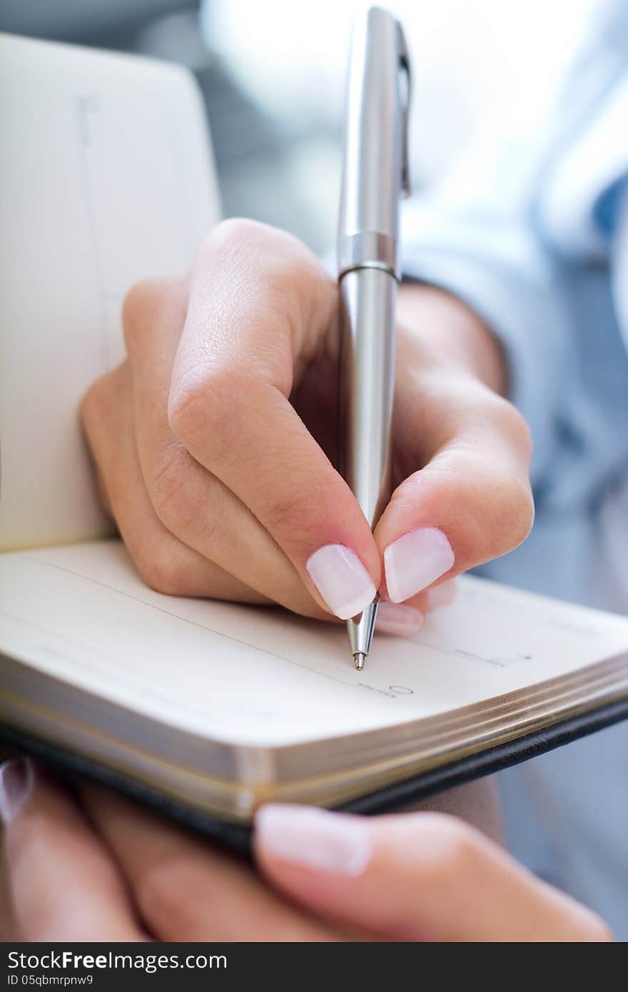 Young woman taking notes at home