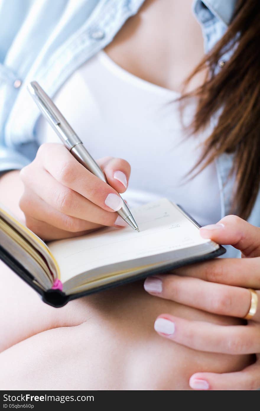 Young woman taking notes at home