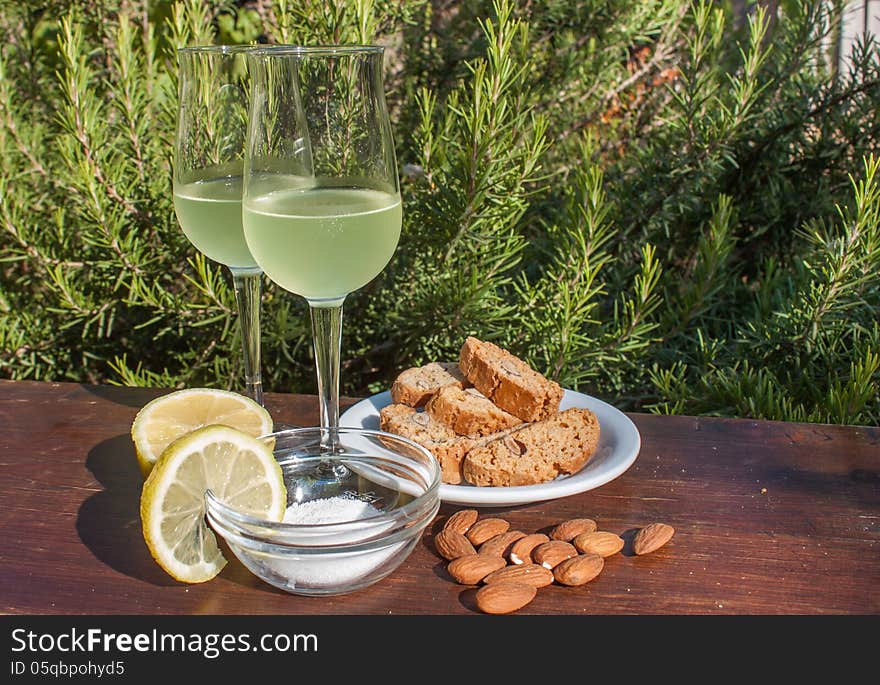 Limoncello - Italian lemon liqueur typically served with biscotti - oblong-shaped almond biscuits. Limoncello - Italian lemon liqueur typically served with biscotti - oblong-shaped almond biscuits