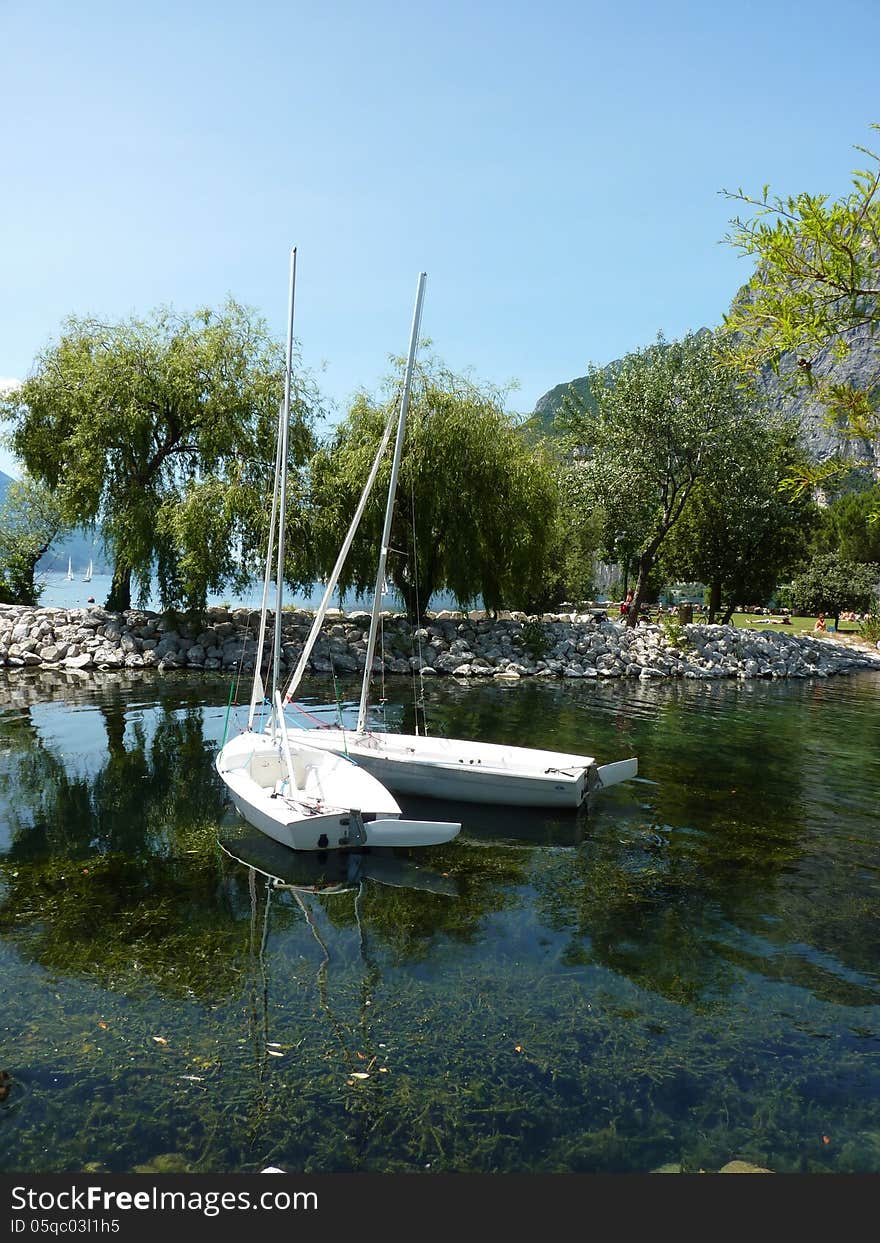 Two boats tied together by the lake