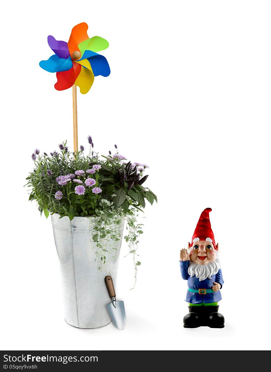 Spring flowers in an aluminum bucket with a toy windmill and gnome. Spring flowers in an aluminum bucket with a toy windmill and gnome