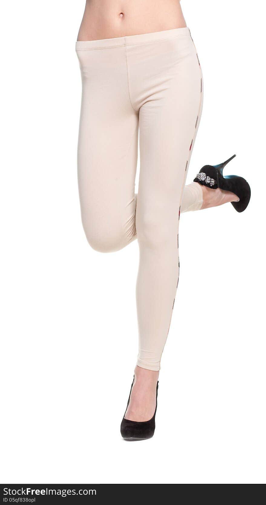 Close up of woman legs in fawn leggins and black shoes on white