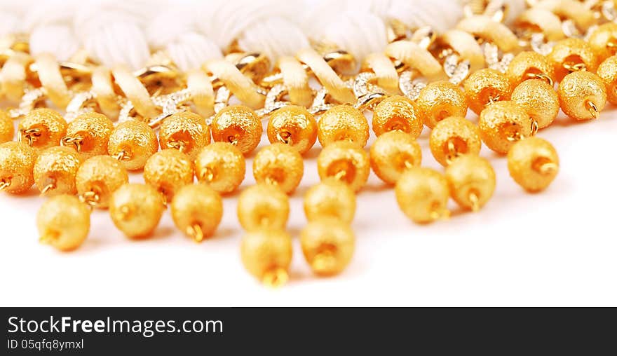 Necklace of gold pearls on a white bacground