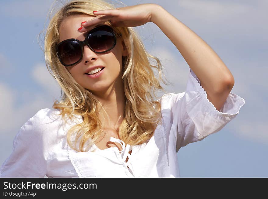 Portrait of beautiful blonde girl on background blue sky. Portrait of beautiful blonde girl on background blue sky