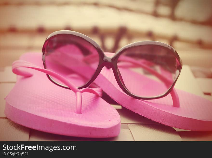 Fashionable women s sunglasses and pink flip flops