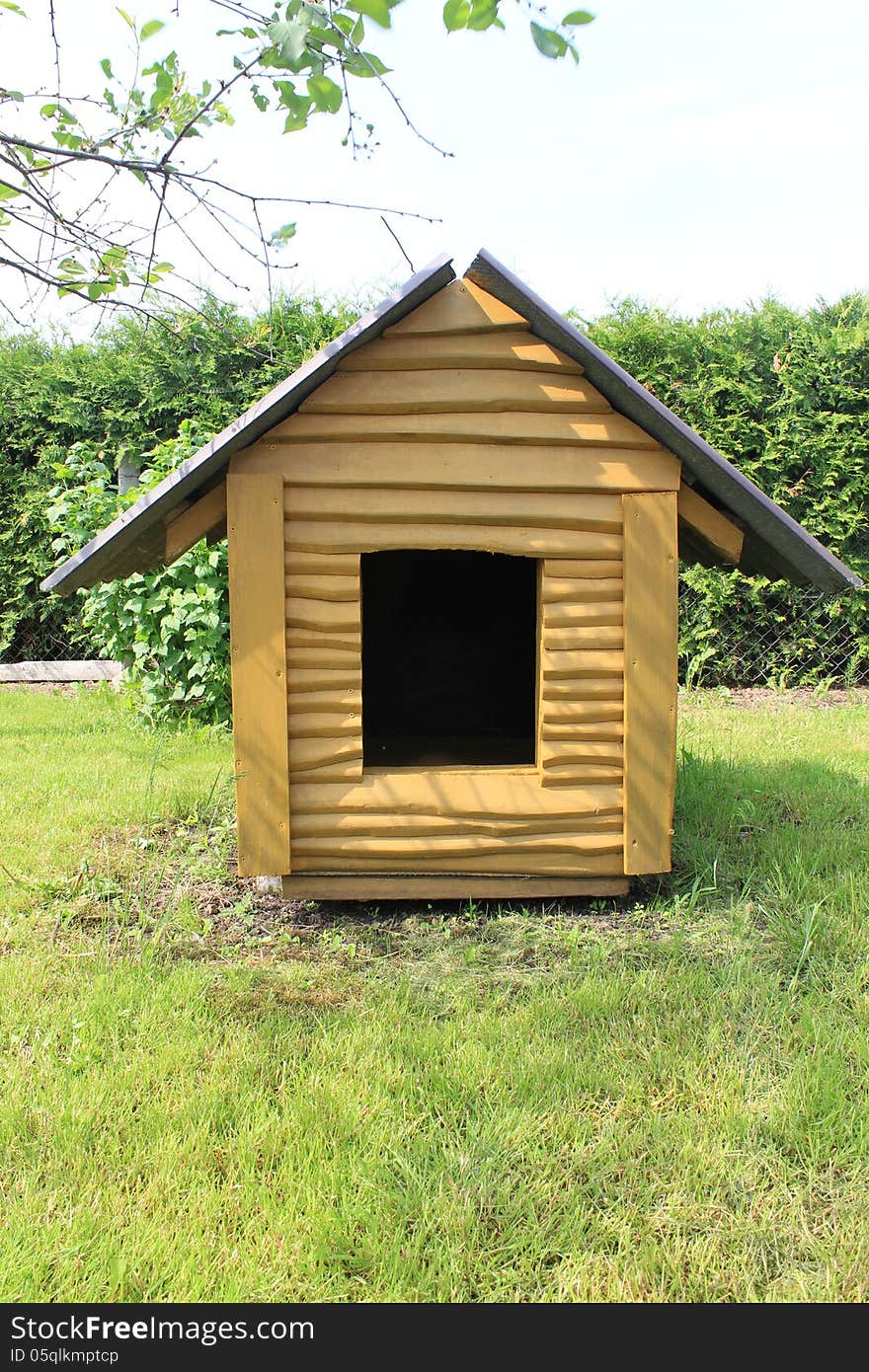 Wooden dog kennel on the grass in the meadow. Wooden dog kennel on the grass in the meadow