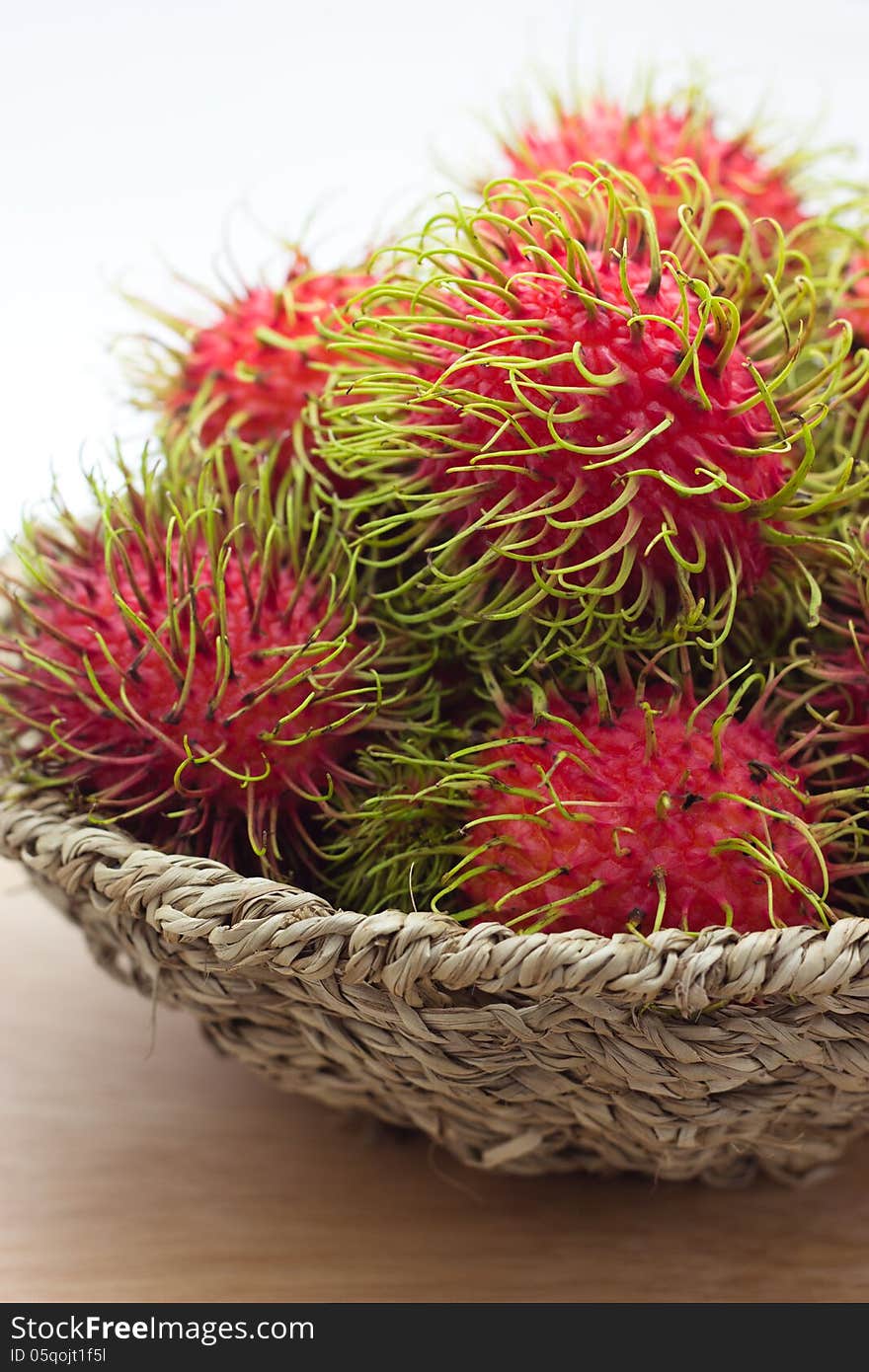 Rambutan in bamboo basket isolated on white background. Rambutan in bamboo basket isolated on white background