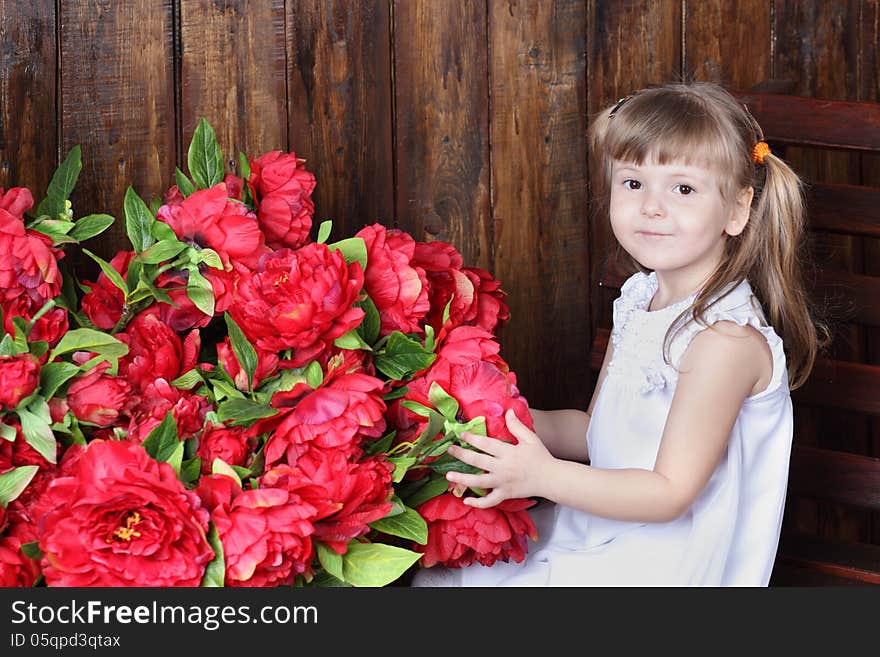 Little beautiful girl in white dress and large bouquet