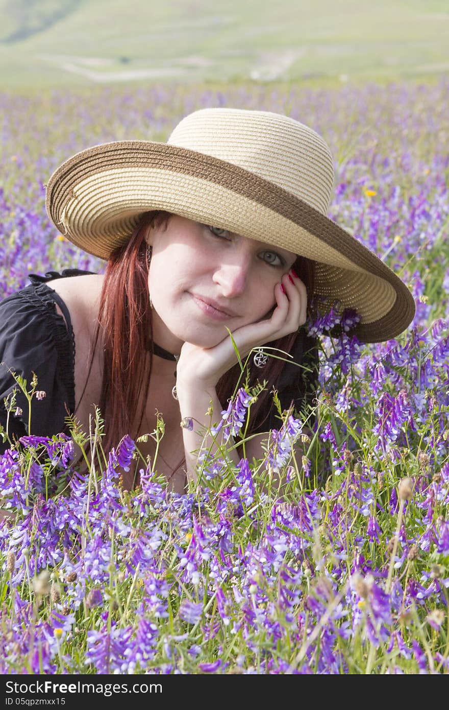 Young attractive girl dreaming in violet flowers.