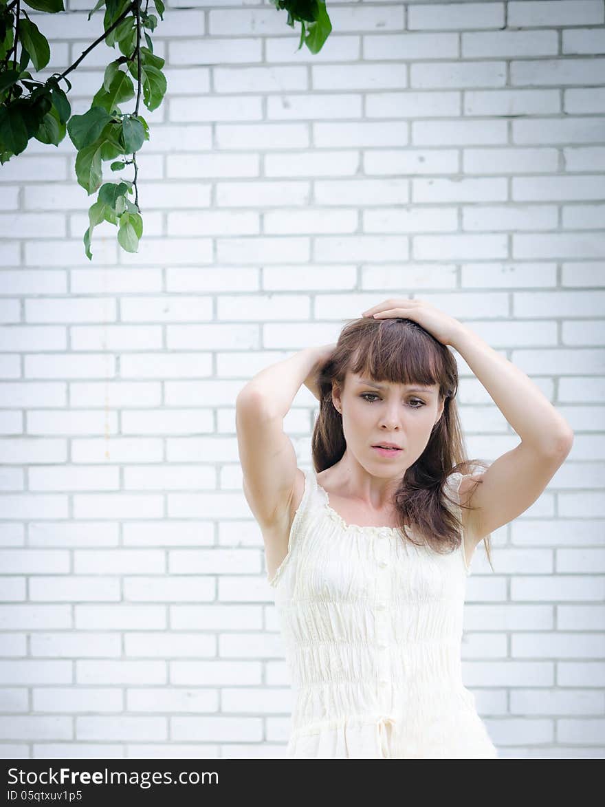 Worried girl stands near the wall