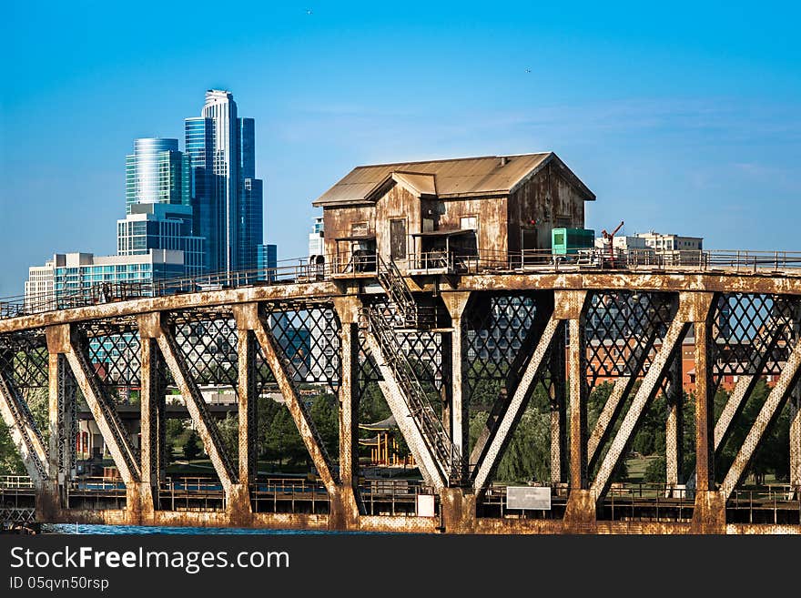 Two types of different architectural styles - rusty industrial structure and residential or business modern high rise building seen in the background. Two types of different architectural styles - rusty industrial structure and residential or business modern high rise building seen in the background.