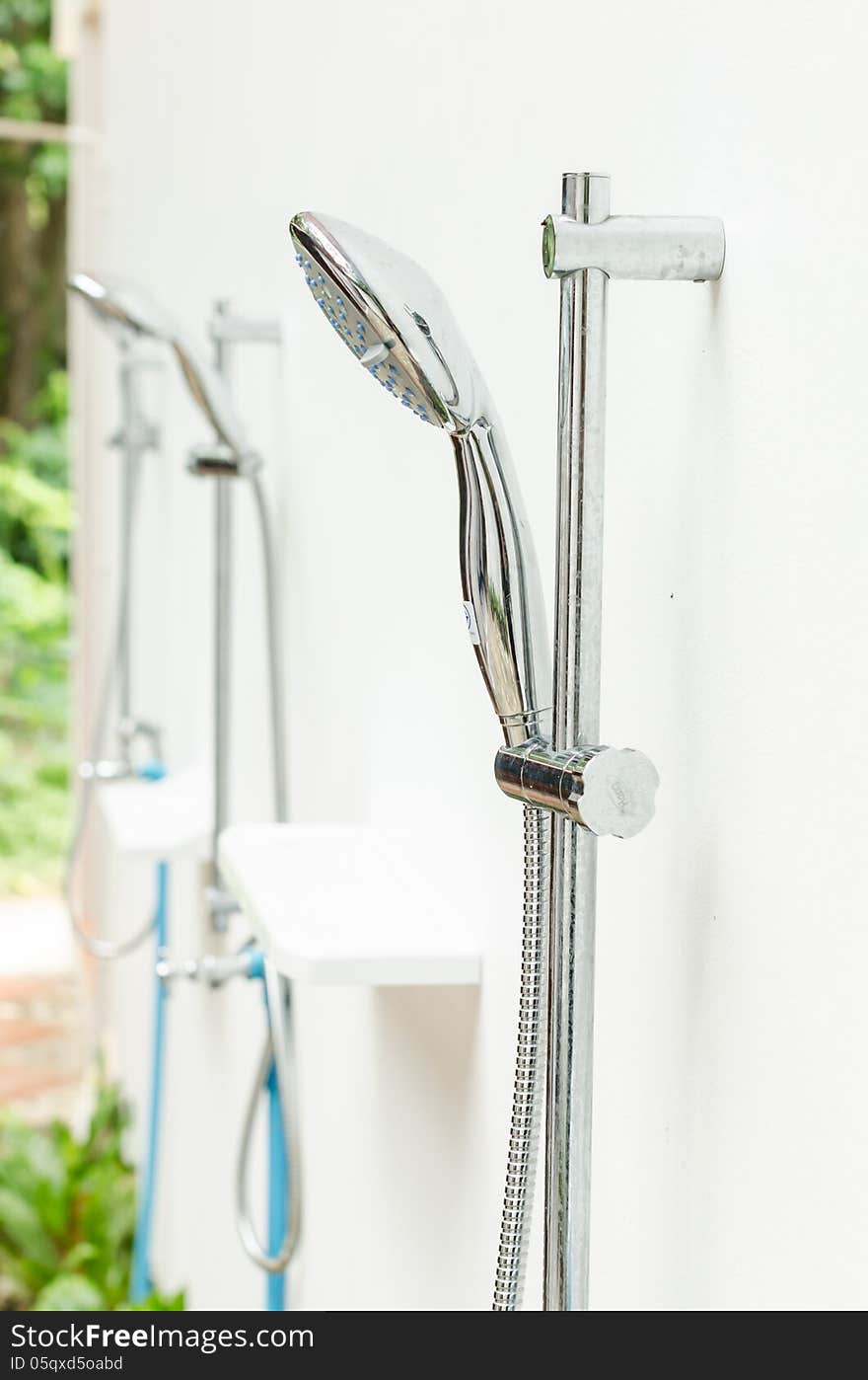 Metal shower outdoor on white wall beside the beach. Metal shower outdoor on white wall beside the beach