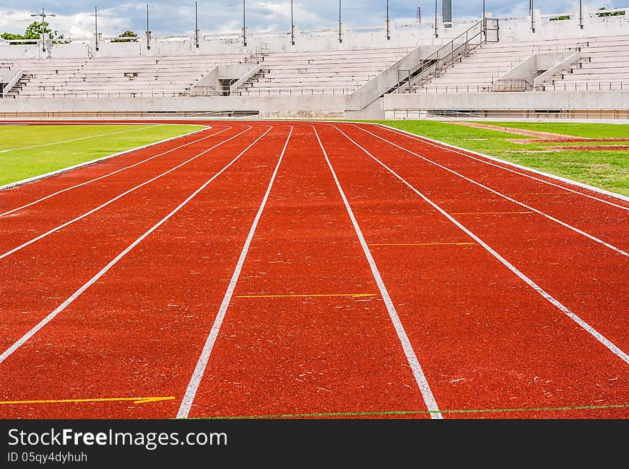 Blank orange track in the stadium (runway) on the side of football field