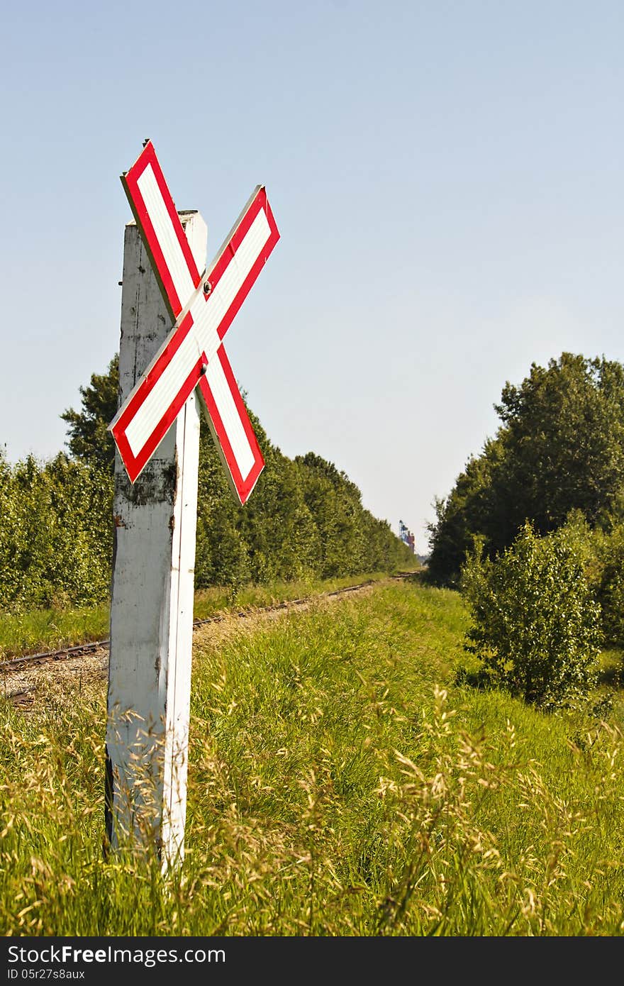 A white and red warning sign for trains crossing country road. A white and red warning sign for trains crossing country road.