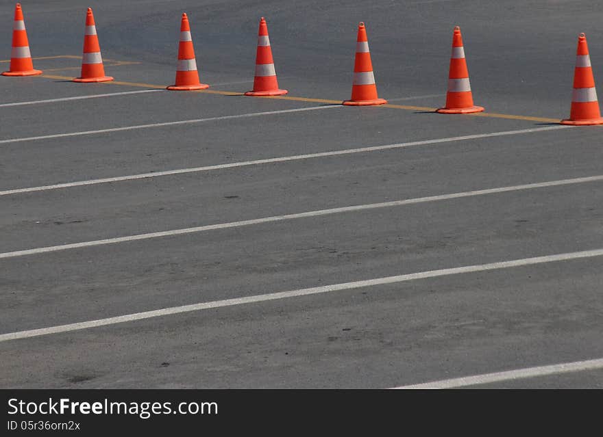 Orange traffic cones in order with white lines