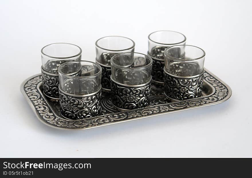 Old silver wine-glasses with pattern on a tray diagonal foreshortening