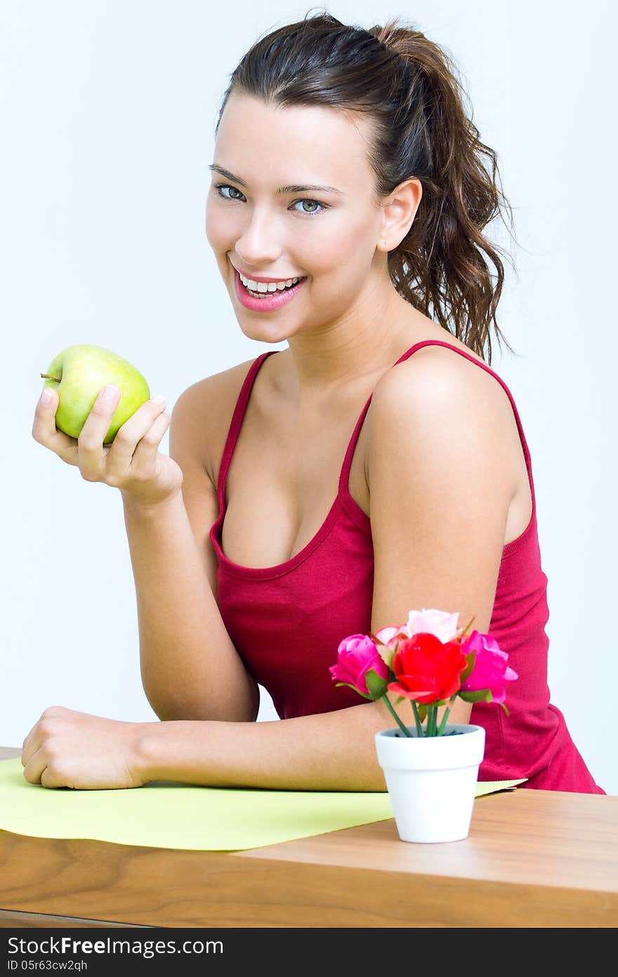 Pretty woman eating one green apple at home